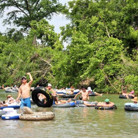 A group of guys sitting in tubes as they float down the river