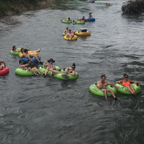 An aerial shot of people floating down the San Marcos river in tubes