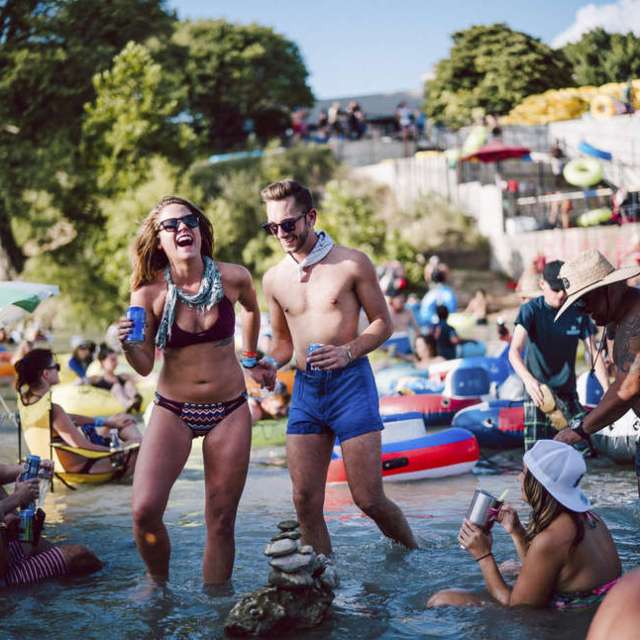 Two girls posing for a picture while standing in the San Marcos River