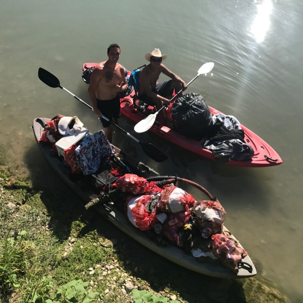 Two men in a kayak bringing supplies with them