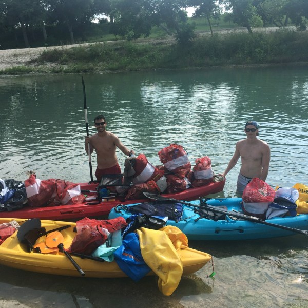 A group of guys loading a kayak before going on a float down the river