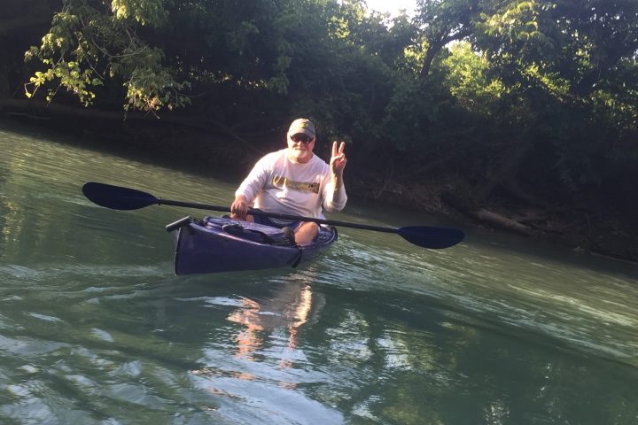 a man riding on the back of a boat in the water