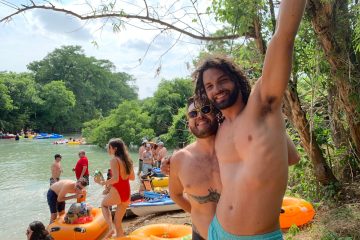 a man and a woman standing in front of a lake